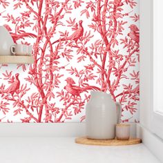 the wallpaper is red and white with birds on it, while two vases sit next to each other