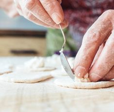 a person is cutting food on a table with a knife and some flour in front of them