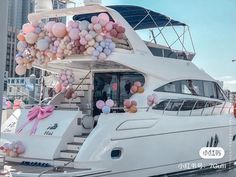 a white boat with balloons attached to it