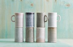 four different colored coffee mugs lined up on a table