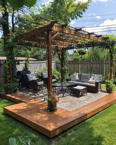 an outdoor living area with couches, table and grill in the middle of it