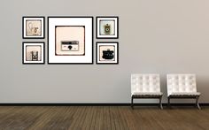 two white chairs sitting next to each other on top of a hard wood floor in front of a gray wall