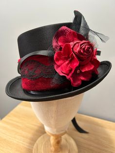 Beautiful Red Black Top Hat  Victorian vintage style  Black Base adorned with Red Satin Rose, Feather , Flowers and Black Flowers , Net , Lace , Feather, Ribbons. Unique design so special to you.  Fabulous for many events - Alternate Wedding, Steampunk event, Circus Ringmaster, Hand fasting, Goth, Festival  Musician, Festival. approx head circumference  56cms   www.maisondecantern.co.uk or find my designs on Facebook / Instagram Red Rose Hat, Fitted Gothic Costume Hats And Headpieces For Themed Events, Fitted Gothic Costume Hats For Themed Events, Fitted Punk Top Hat For Party, Fitted Punk Style Top Hat For Party, Punk Style Fitted Top Hat For Party, Fitted Gothic Mini Hats For Themed Events, Gothic Wedding Costume Hat And Headpiece, Black And Red Goth Outfit