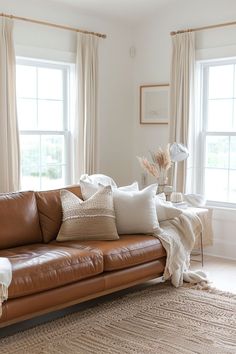 a living room filled with lots of furniture and pillows on top of a brown couch