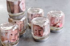 a group of glass jars filled with pictures of babies in them on a counter top