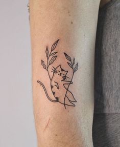 a woman's arm with a cat tattoo on the left side of her arm