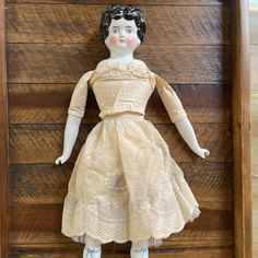 an antique doll in a wooden box on display