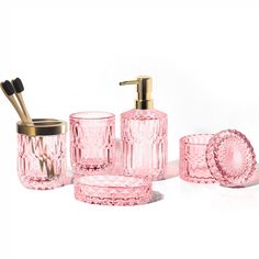 pink glass bathroom accessories including soap dispenser and toothbrush holder