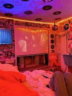 a person laying on a bed in front of a projector screen and some lights