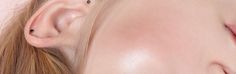 a close up of a woman's face with ear piercings on her ears