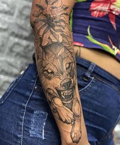 a woman with a tattoo on her arm and the wolf is holding flowers in her hand