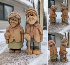 two wooden statues of people standing next to each other in the snow and one is holding an umbrella