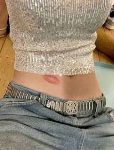 a woman's stomach with the bottom part covered in glitter and has her hand on her hip