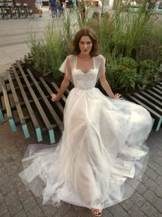 a woman in a white dress sitting on a bench