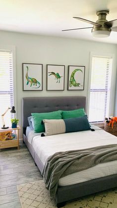 a bedroom with a bed, dresser and pictures on the wall