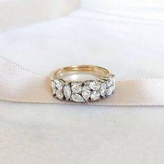 an image of a wedding ring setting on a white satin ribbon with diamond stones in the middle