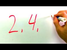 someone writing numbers on a piece of paper with red marker and white eraser next to it