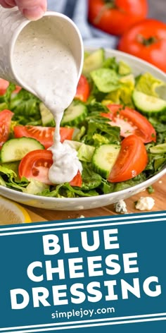 blue cheese dressing being drizzled over a salad with tomatoes and cucumbers