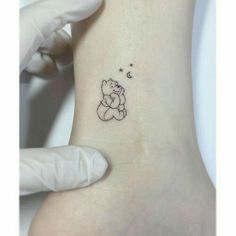 a person with a small tattoo on their arm holding onto the back of her stomach