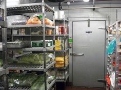 the inside of a large industrial kitchen with lots of food on shelving and shelves