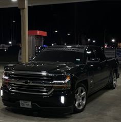 a black truck parked in a parking lot at night