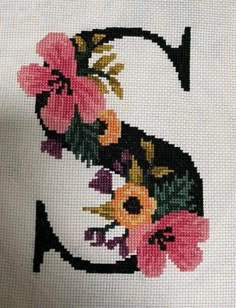 a cross stitched letter with flowers on it's uppercase and lowercase