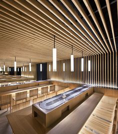 an empty bathtub in the middle of a room with wooden walls and ceiling lights