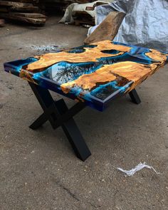 a coffee table made out of wood with blue and yellow paint on it's surface