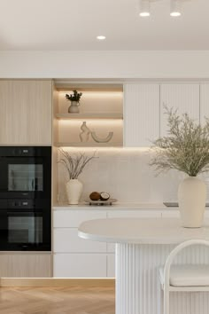 a white kitchen with an oven and table in it