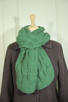 a woman wearing a green scarf on top of a mannequin