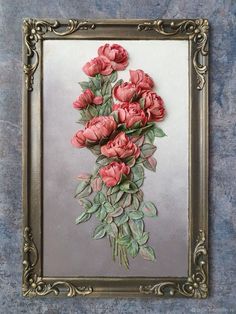 a painting of pink flowers in a gold frame on a blue and gray background with green leaves