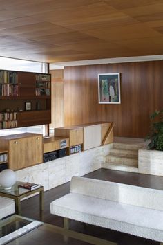 a living room filled with furniture and bookshelves next to a plant on top of a table