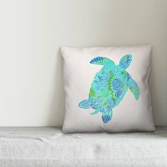 a blue turtle pillow sitting on top of a white couch