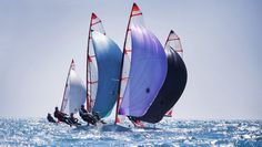 three sailboats are sailing in the open water