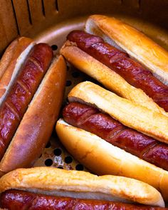 several hotdogs and buns in a basket