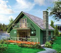 a small green house with a porch next to a lake