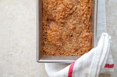 a loaf of bread sitting on top of a pan next to a white towel and napkin