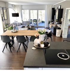 a kitchen and living room are shown in this modern style home with wood flooring