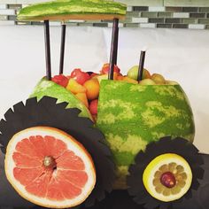 a watermelon car made to look like it has wheels and fruits in the back