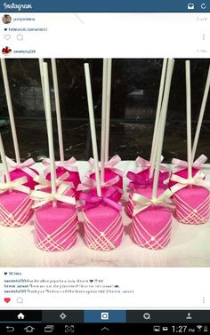 there are many pink candies with white sticks in the shape of hearts and bows