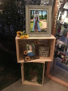 a wooden shelf with pictures and flowers on it