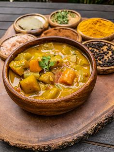 a wooden bowl filled with soup on top of a table