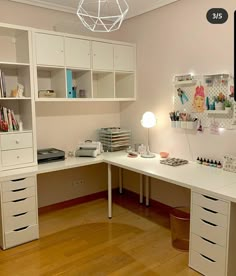 a white desk with lots of drawers on top of it and a light hanging from the ceiling