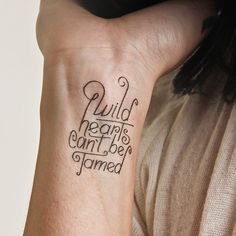 a woman with a tattoo on her arm that says wild hearts can't be tame