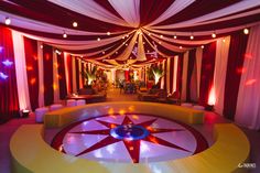 a room decorated in red, white and yellow with lights on the ceiling is shown