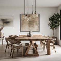 a dining room table with chairs and art hanging above it