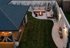 an aerial view of a backyard with fire pit and seating area in the evening time