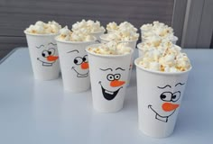 five cups with popcorn in them and faces drawn on the side, all lined up