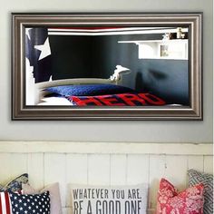 a bed with pillows and an american flag pillow on top of it in a bedroom