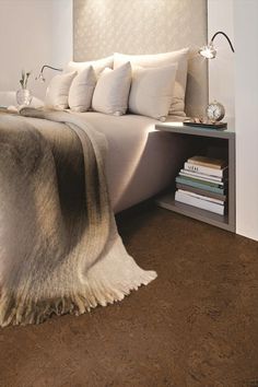 a bed sitting next to a book shelf filled with books